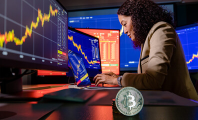Close up shot of bitcoin cryptocurrency in front of female Asian broker trader investor type on...