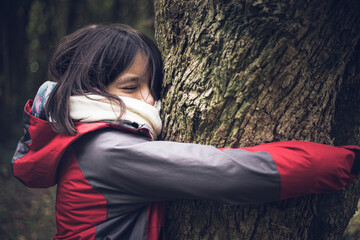 Naklejka premium niñas adolescentes abrazando árbol y agradeciendo a la madre naturaleza