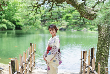日本庭園を散策する浴衣の女性