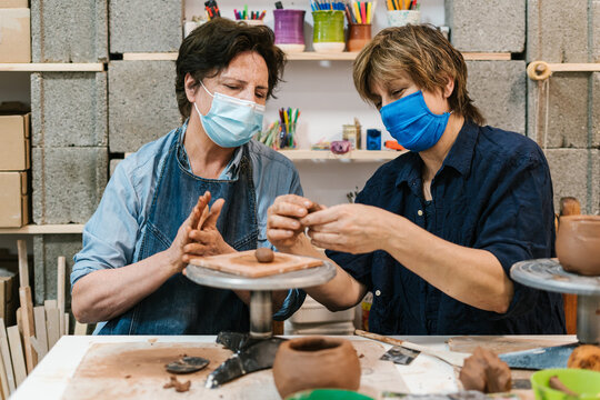 Women potters with masks at pottery classes