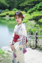 日本庭園を散策する浴衣の女性