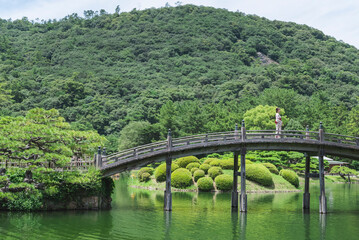 日本庭園を散策する浴衣の女性