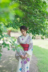 日本庭園を散策する浴衣の女性