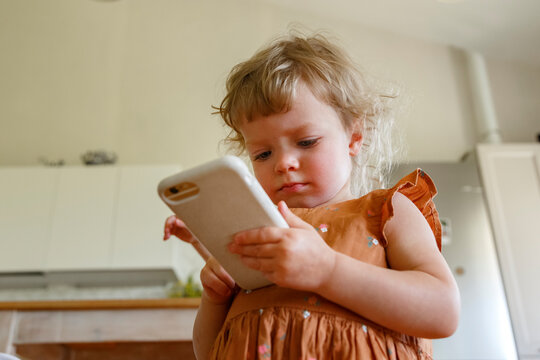 Cute toddler using smartphone at home