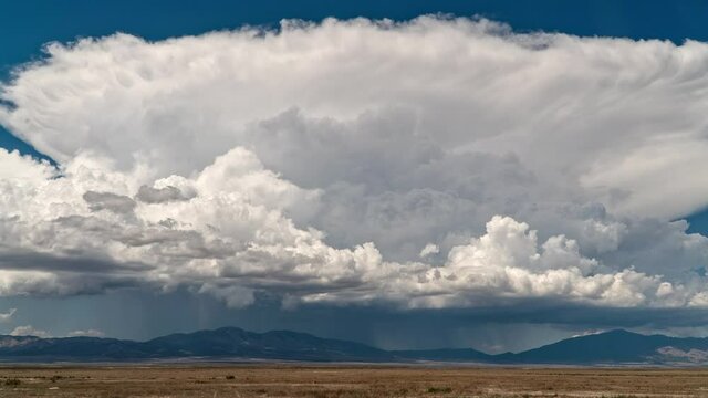 Giant cumulonimbus clouds in the Utah desert as thunderstorm forms moving in timelapse.