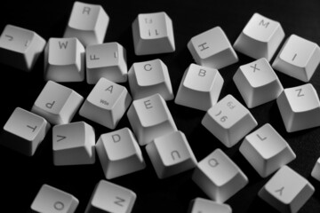 Random letters of keycaps or keyboard buttons on black background. Random Alphabet.