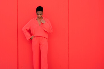 Beautiful Female With Electric red Suit Against Red Wall