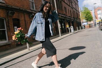 Happy Asian Woman Crossing the Street with Flowers