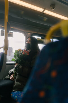 Woman on the Bus with mask and Flowers