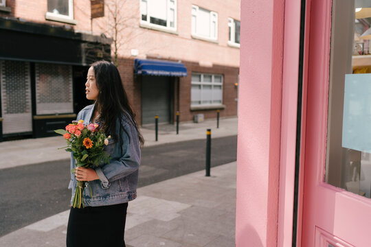 Confident Woman Walking with Flowers