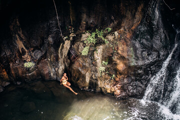 African black woman swimming at lake with waterfall