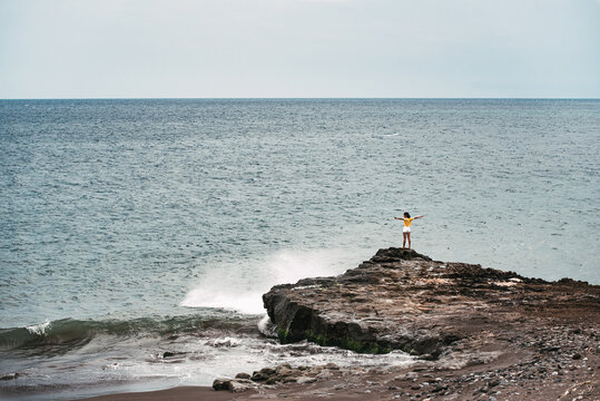 Woman standing in a cliff seashore