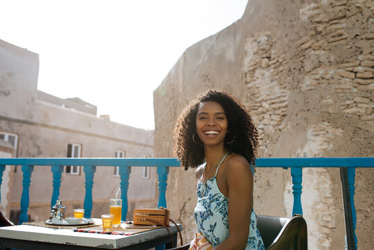Beautiful black woman sitting in a coffee balcony