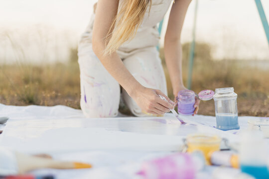 Woman artist mixing colors at nature