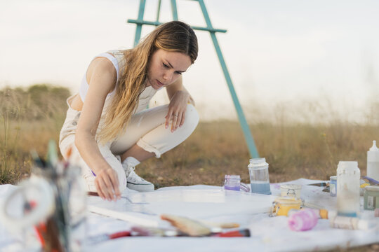 Woman artist mixing colors at nature