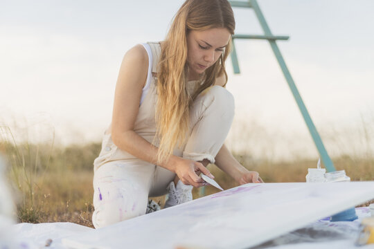 Woman artist mixing colors at nature