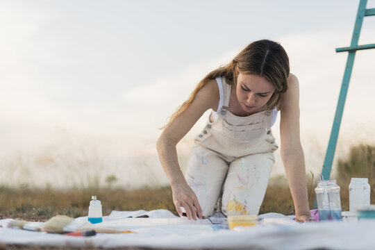 Woman artist mixing colors at nature