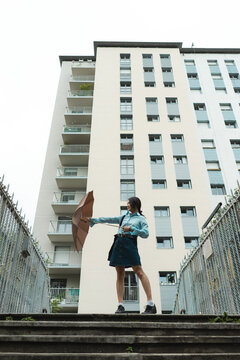 Young woman standing in front of housing building 
