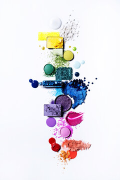 Colourful cosmetics flat lay rainbow with powder, liquid and glitter