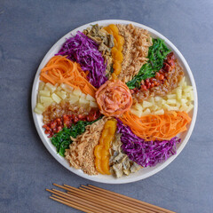 Colorful and circular arrangement of Chinese festive cuisine. Carousal of Prosperity Toss.