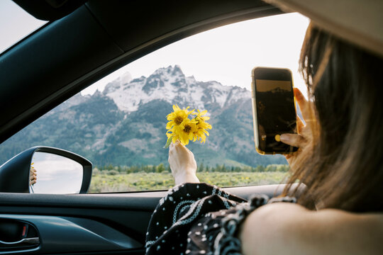 Woman taking picture on road trip
