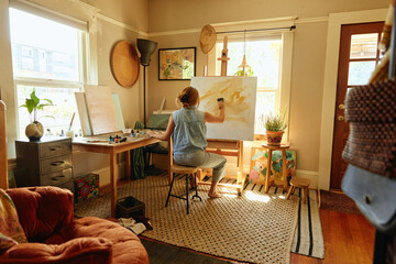 Woman painting in a home studio. 