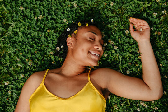  Black Woman Laying Down In The Grass.