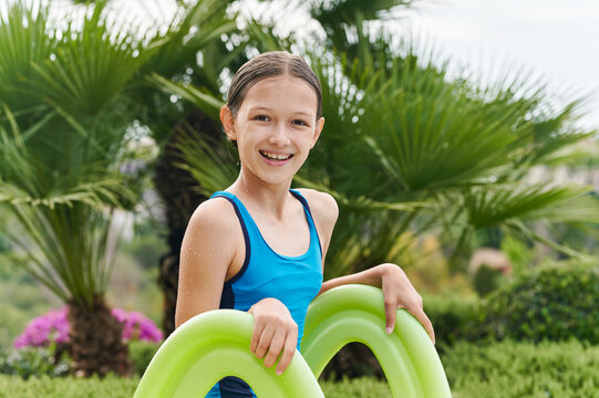 Smiling little girl standing on a pool slide