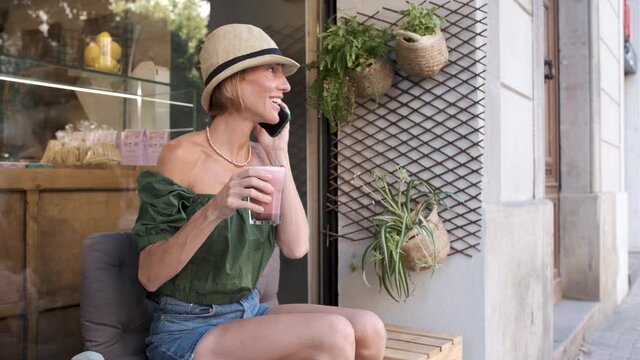 Young Adult Fitness Woman Using Smartphone And Drinking Healthy Matcha Pink Drink