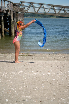 Girl on beach puts on mermaid tail swimsuit

