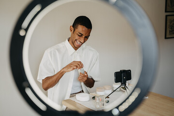 Young man doing beauty routine video tutorial at home