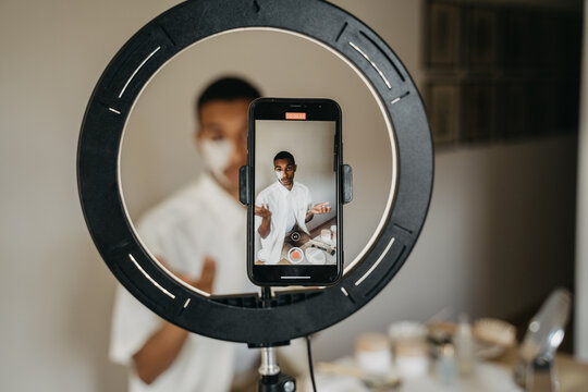Young man doing beauty routine video tutorial at home