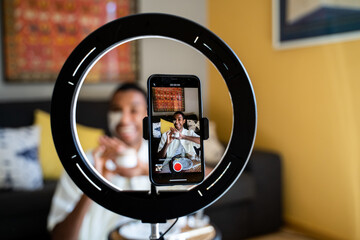 Young man doing beauty routine video tutorial at home