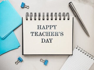 Happy Teacher's Day. Notepad with a congratulatory inscription. Close-up, view from above. No people. Concept of preparation for a holiday. Congratulations for relatives, friends and colleagues