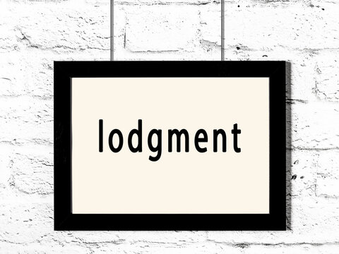 Black frame hanging on white brick wall with inscription lodgment