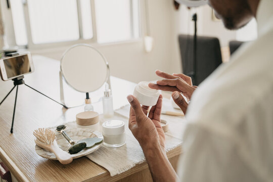 Young man doing beauty routine video tutorial at home