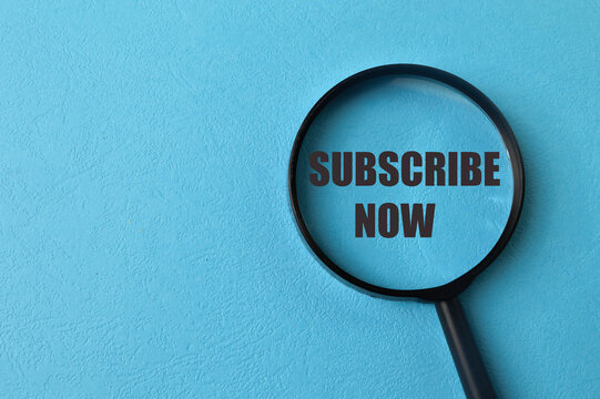 Magnifying glass with phrase SUBSCRIBE NOW isolated on blue background
