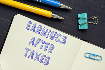 Conceptual photo about EARNINGS AFTER TAXES with written text.