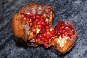Moldy pomegranate with black background closeup