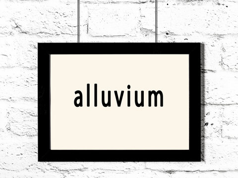 Black Frame Hanging On White Brick Wall With Inscription Alluvium