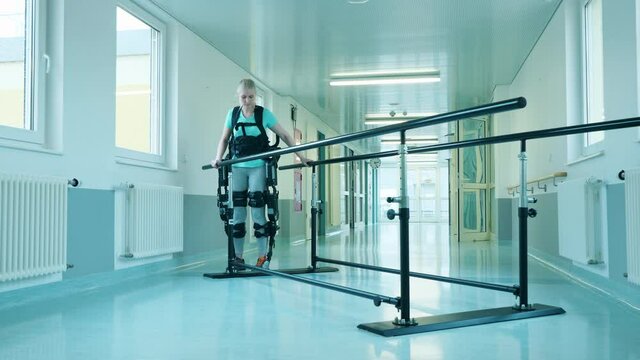 Disabled woman is doing physiotherapy in the exosuit