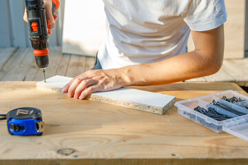 Handyman in blue uniform works with electricity automatic screwdriver. House renovation conception.