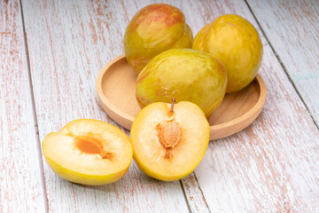 Fresh green plum, Granate Plum on wooden background.