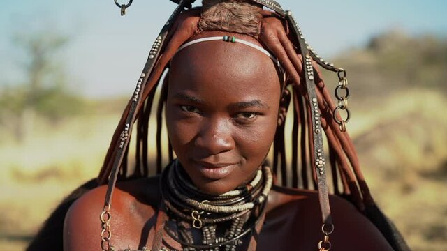 Beautiful Himba woman in traditional Himba village near Kamanjab in Namibia, Africa, slow motion shot.  