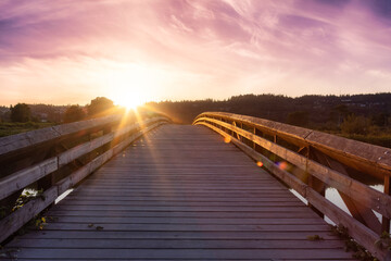 Bridge going over a river in a city park. Dramatic Summer Sunset Sky Art Render. Colony Farm Regional Park, Port Coquitlam, Vancouver, British Columbia, Canada.