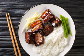 Rafute is the Okinawan version of simmered pork belly served with rice closeup in the plate on the table. Horizontal top view from above
