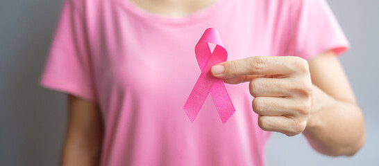 October Breast Cancer Awareness month, elderly Woman in pink T- shirt with hand holding Pink Ribbon for supporting people living and illness. International Women, Mother and World cancer day concept - obrazy, fototapety, plakaty