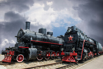Heavy powerful Sovetsky Steam locomotive. Colored steam locomotive on a black and white background.