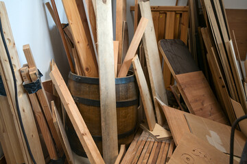 Fototapeta na wymiar Storage of wood scraps, laths, battens and boards in the workshop of a craftsman, selected focus