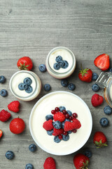 Concept of tasty breakfast with yogurt on gray textured table